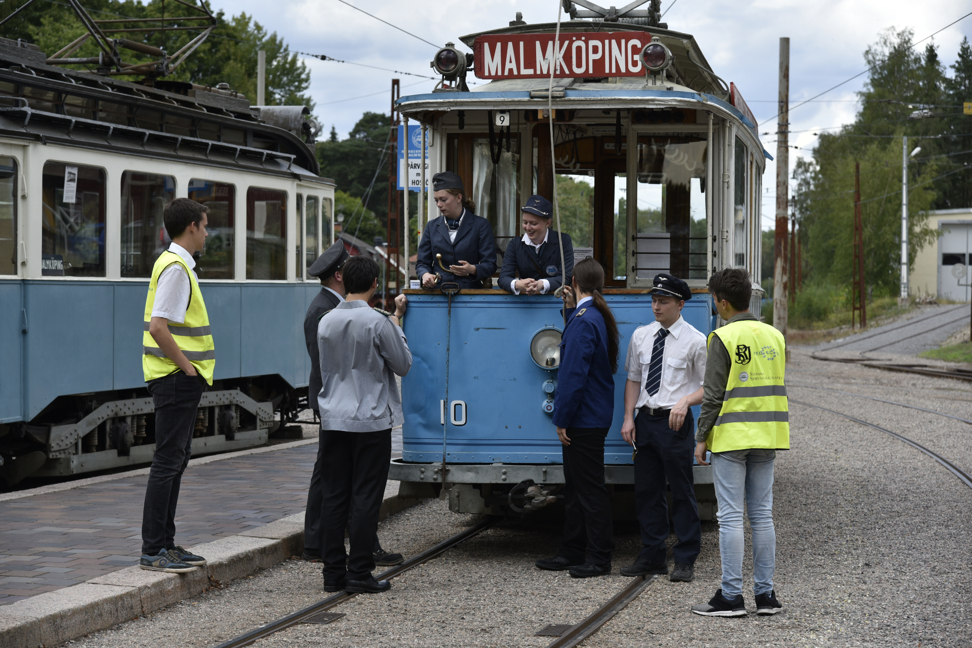 Konduktörer vid vagn 10 i Malmköping omgivna av funktionärer