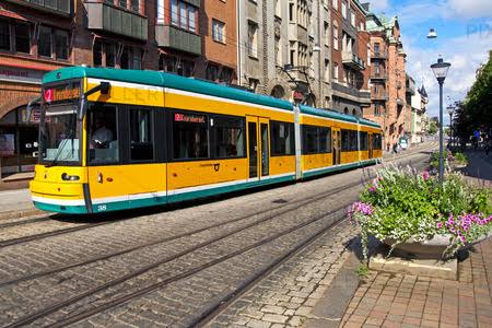 Gul och grön modern spårvagn på gata i Norrköping