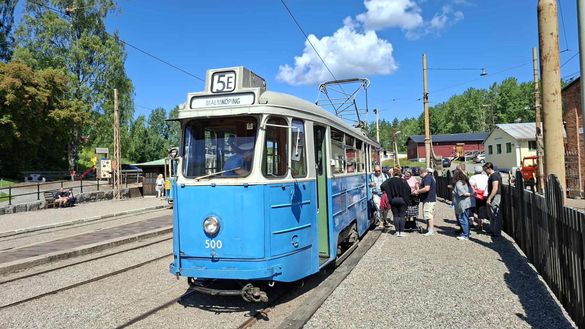 Spårvagn 500 vid hållplats i Malmköping med besökare